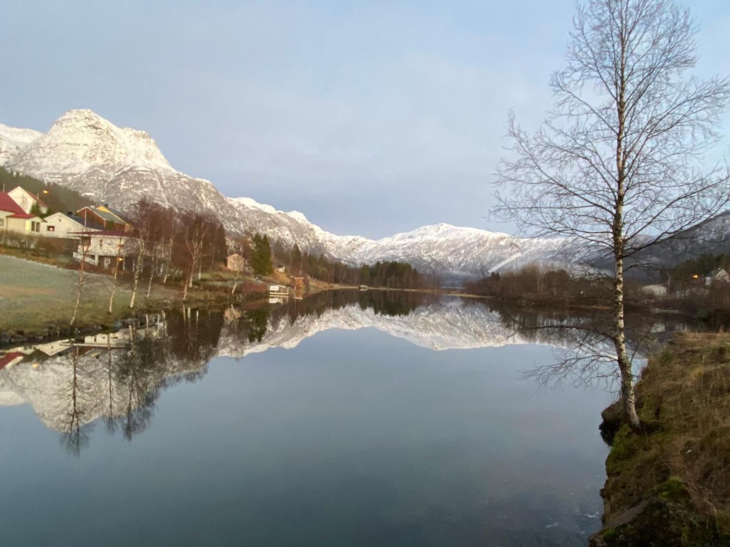 Snow-covered mountains mirrored in the lake, the view from the apartment